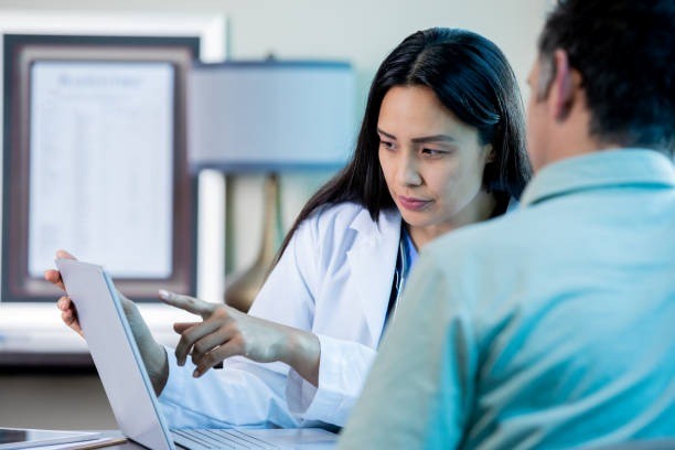 Doctor showing information to patient on a laptop