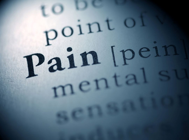 Dictionary definition of “pain” in close detail, representing chronic pain conditions and non-surgical pain treatment